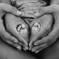 grayscale-photo-of-person-holding-feet-and-hands-1912359